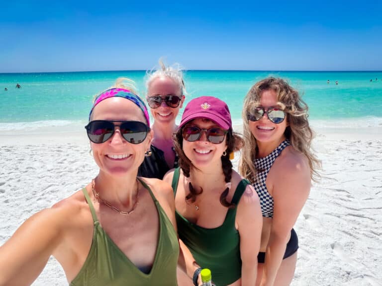 Woman in swimsuits smiling in a selfie at the beach