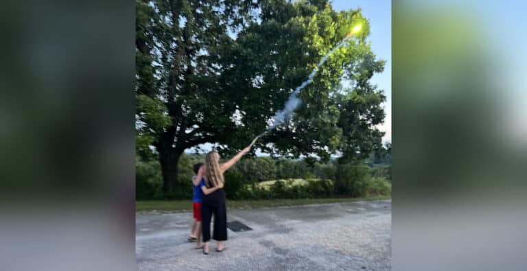 Mom and young son shooting off firework