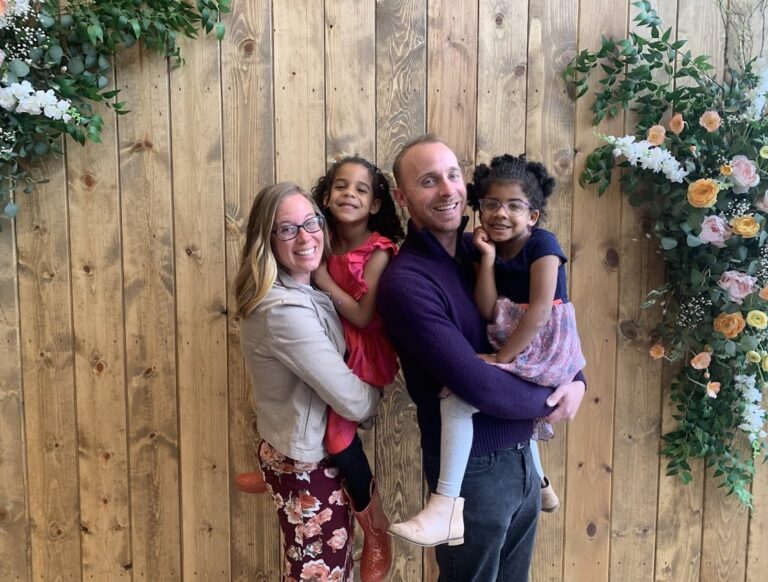 Family posing by wooden wall