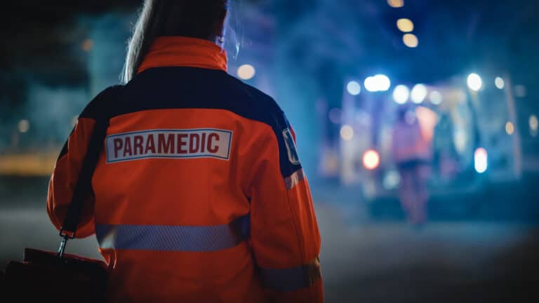 First responder paramedic and ambulance in background