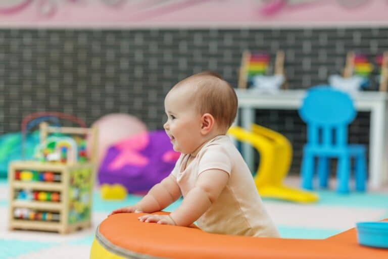 Happy baby standing in toy at daycare