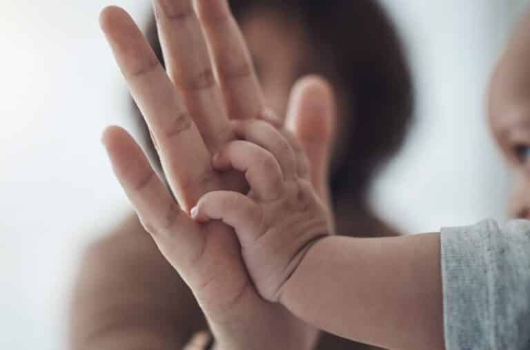 Mother holding baby's hand