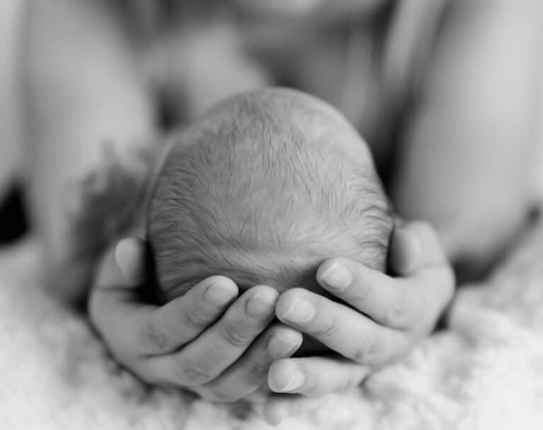 Woman holding baby's head in hands